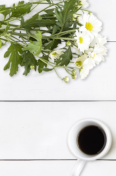 Schreibtisch mit Blumen und Kaffee